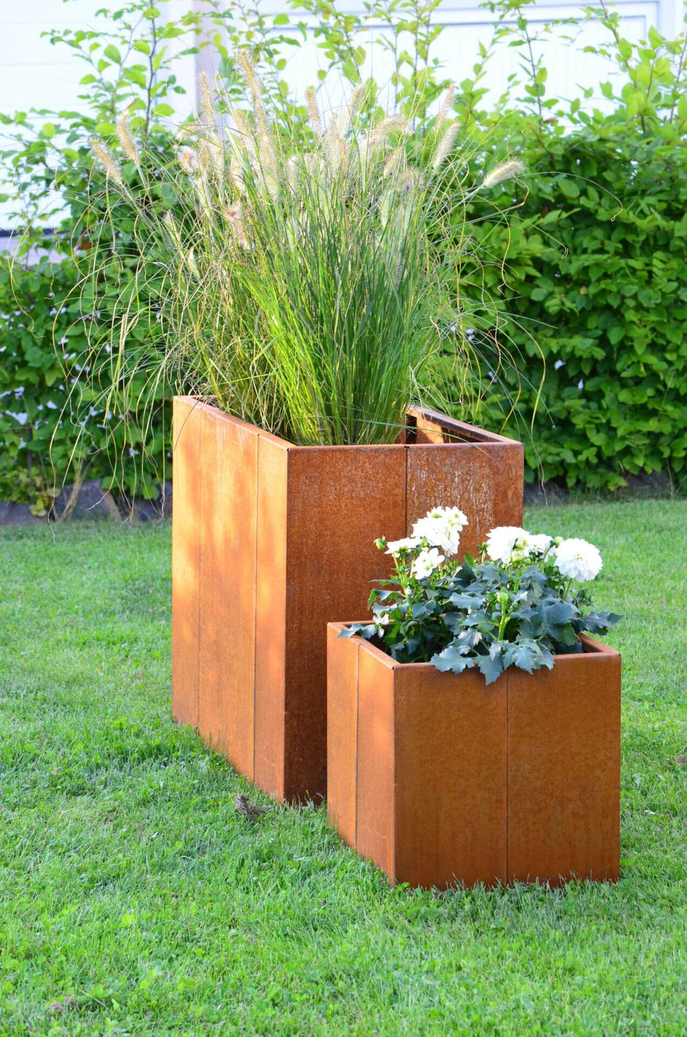 Hochbeet Monterosso freistehend in einem Garten neben einem ELEO Pflanzkübel  Cortenstahl Hochbeet Monterosso freistehend in einem Garten neben einem ELEO Pflanzkübel  Cortenstahl