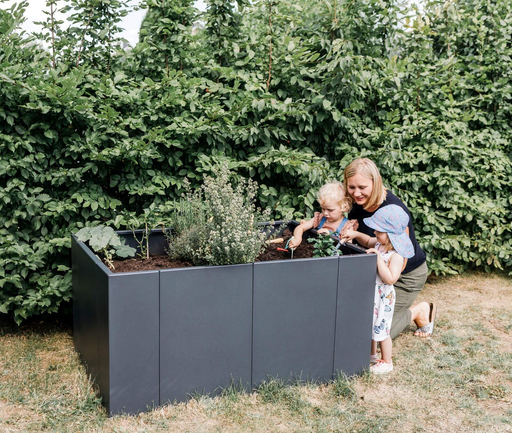 Hochbeet Monterosso wird bepflanzt von einer Mama mit ihren Kindern | Pulverbeschichtet anthrazit Hochbeet Monterosso wird bepflanzt von einer Mama mit ihren Kindern | Pulverbeschichtet anthrazit